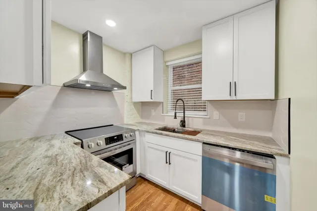 a kitchen with stainless steel appliances granite countertop a sink stove and cabinets