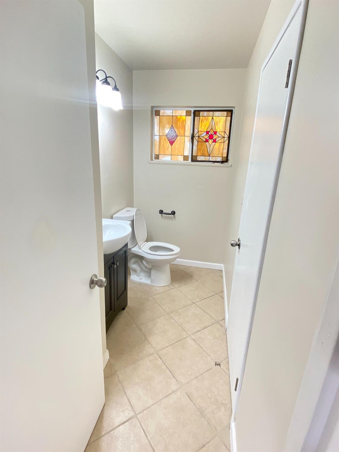 3310 East Hampton Way Fresno, CA 93726 - Photo 11 of 18 a bathroom with a toilet a sink and a window