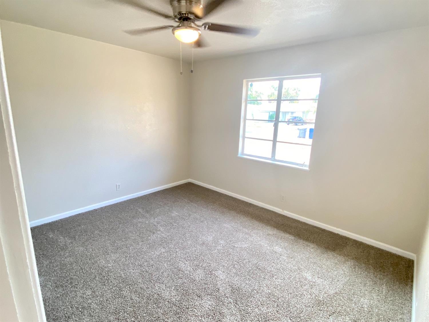 3310 East Hampton Way Fresno, CA 93726 - Photo 12 of 18 an empty room with a window and a fan