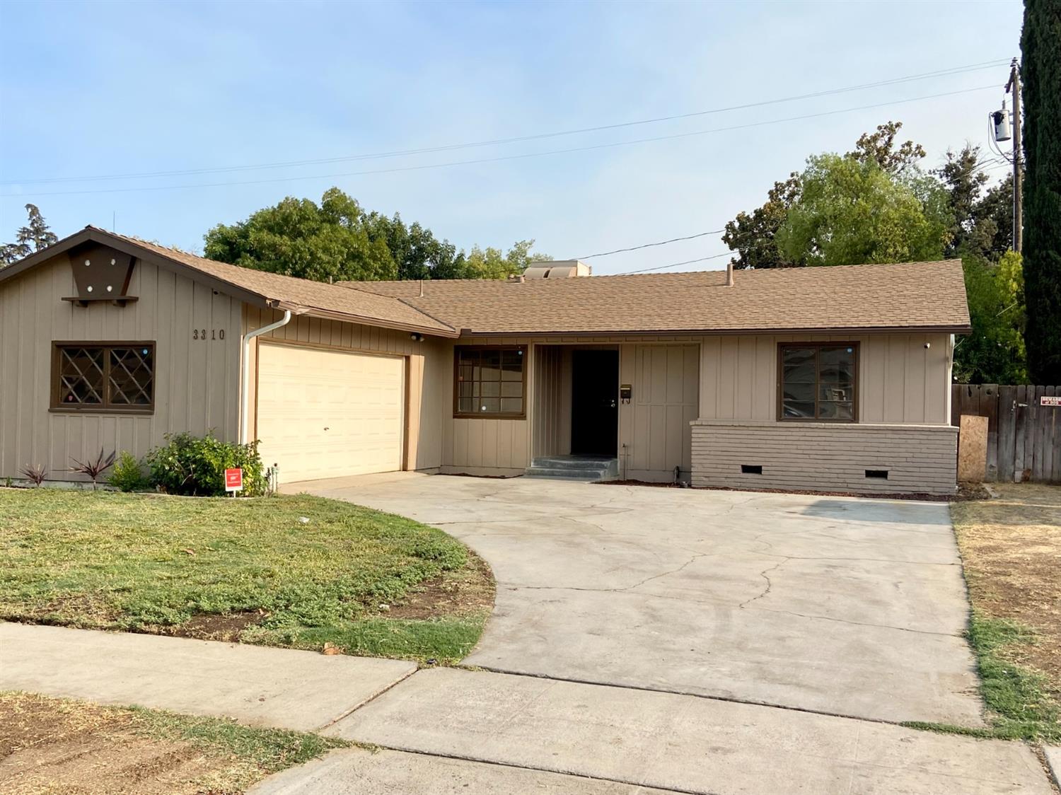 3310 East Hampton Way Fresno, CA 93726 - Photo 18 of 18 a front view of a house with a yard and garage