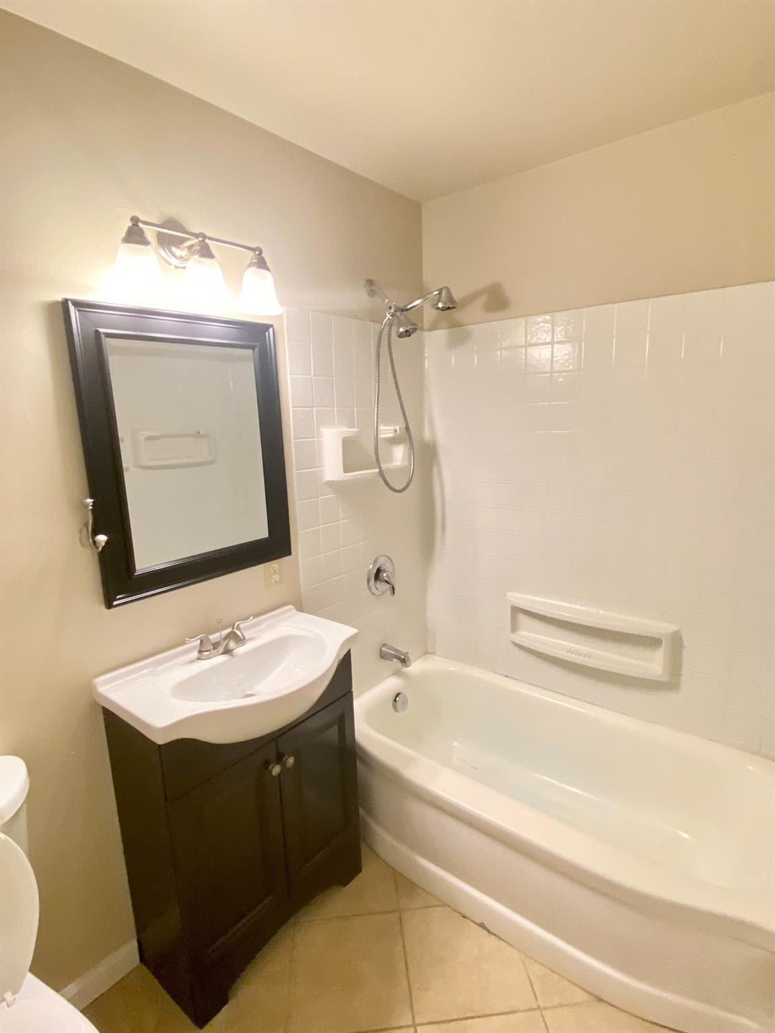 3310 East Hampton Way Fresno, CA 93726 - Photo 4 of 18 a bathroom with a sink vanity mirror bathtub shower and toilet