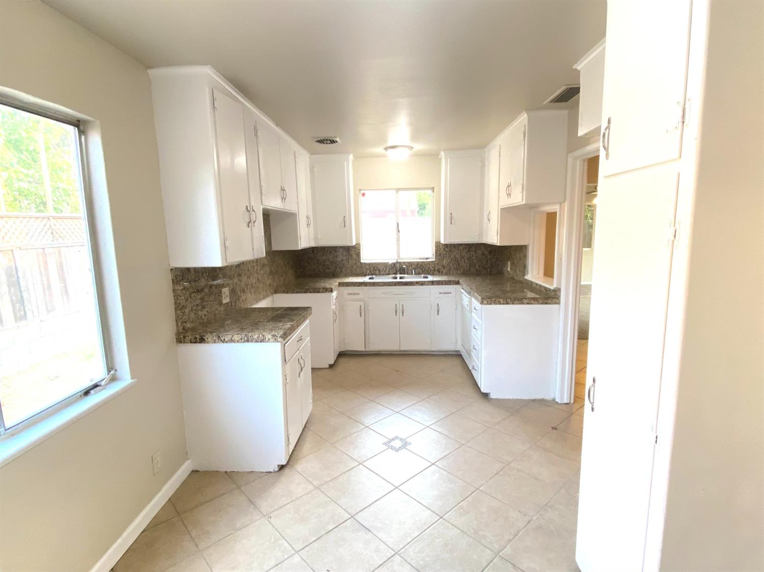 3310 East Hampton Way Fresno, CA 93726 - Photo 7 of 18 a kitchen with a sink a stove a microwave and cabinets