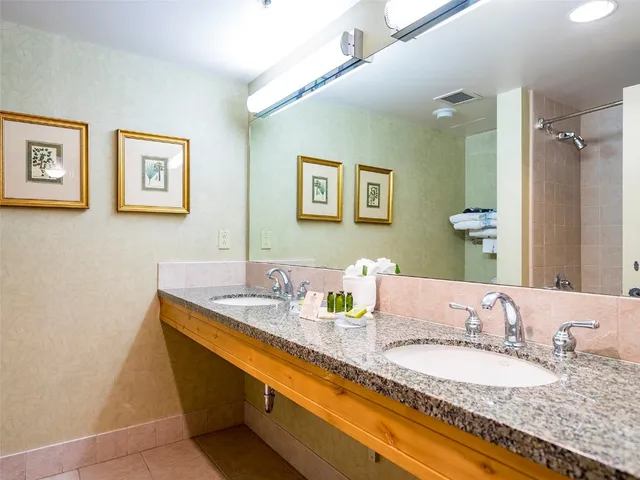 a bedroom with two beds and painting on the wall