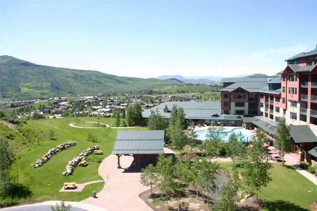 an aerial view of residential houses with outdoor space and trees