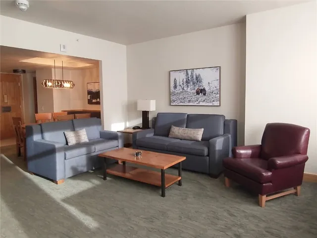a living room with furniture and a view of kitchen