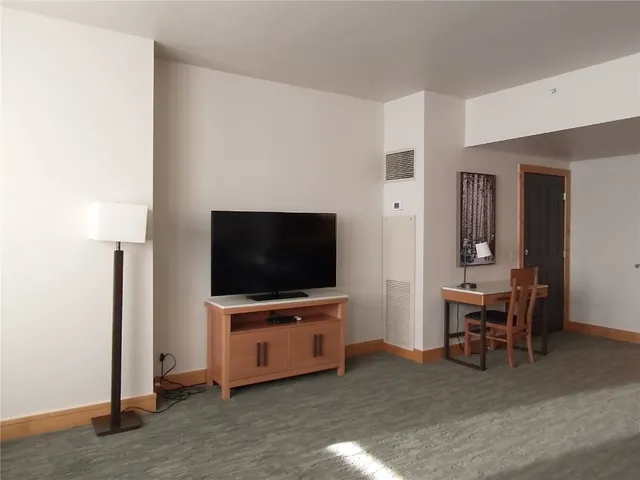 a view of a dining room with furniture a chandelier and wooden floor