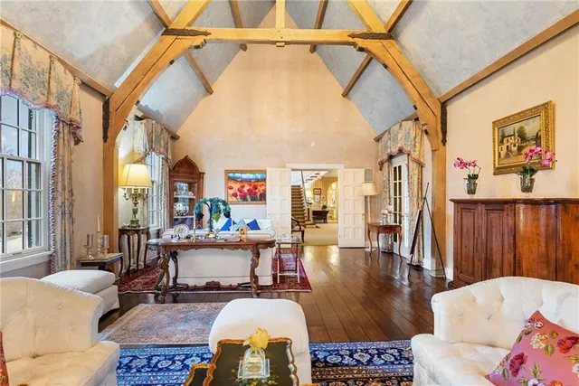 a living room with furniture and a dining table with wooden floor