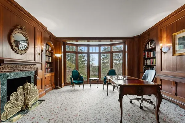 a living room with furniture a fireplace and large windows