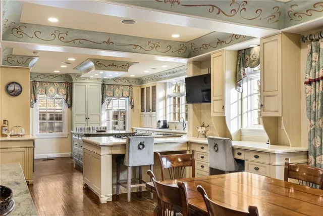 a kitchen with a stove a sink dishwasher and a dining table with wooden floor