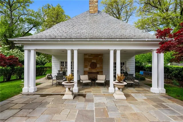 a view of a patio with table and chairs potted plants and floor to ceiling window