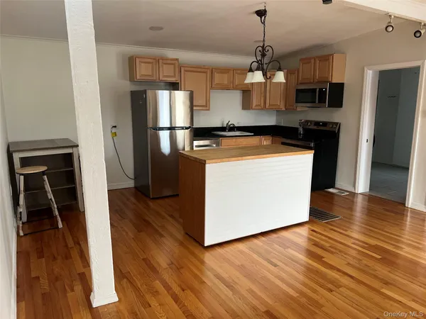 a kitchen with stainless steel appliances granite countertop a refrigerator a stove top oven a sink and dishwasher