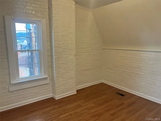 a view of a small space with wooden floor and a window
