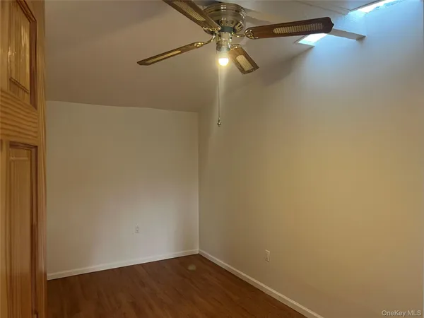a view of a small space with wooden floor and fan