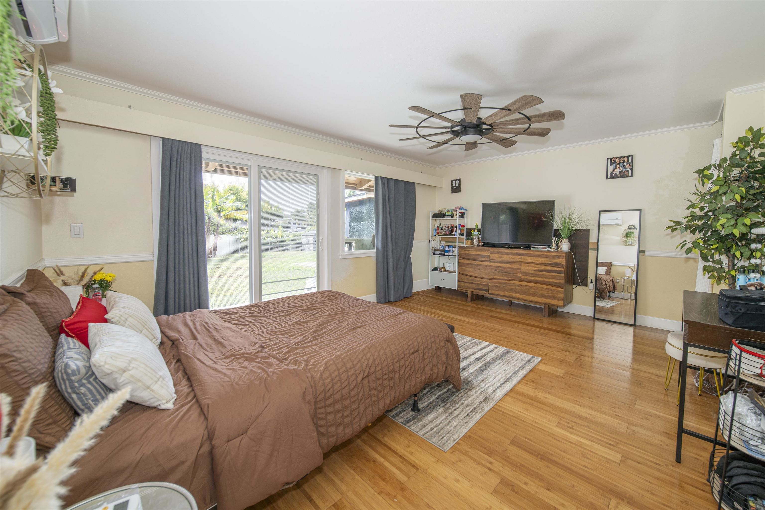 4996 Lower Honoapiilani Road Lahaina, HI 96761 - Photo 14 of 37 a bedroom with a bed dresser and wooden floor