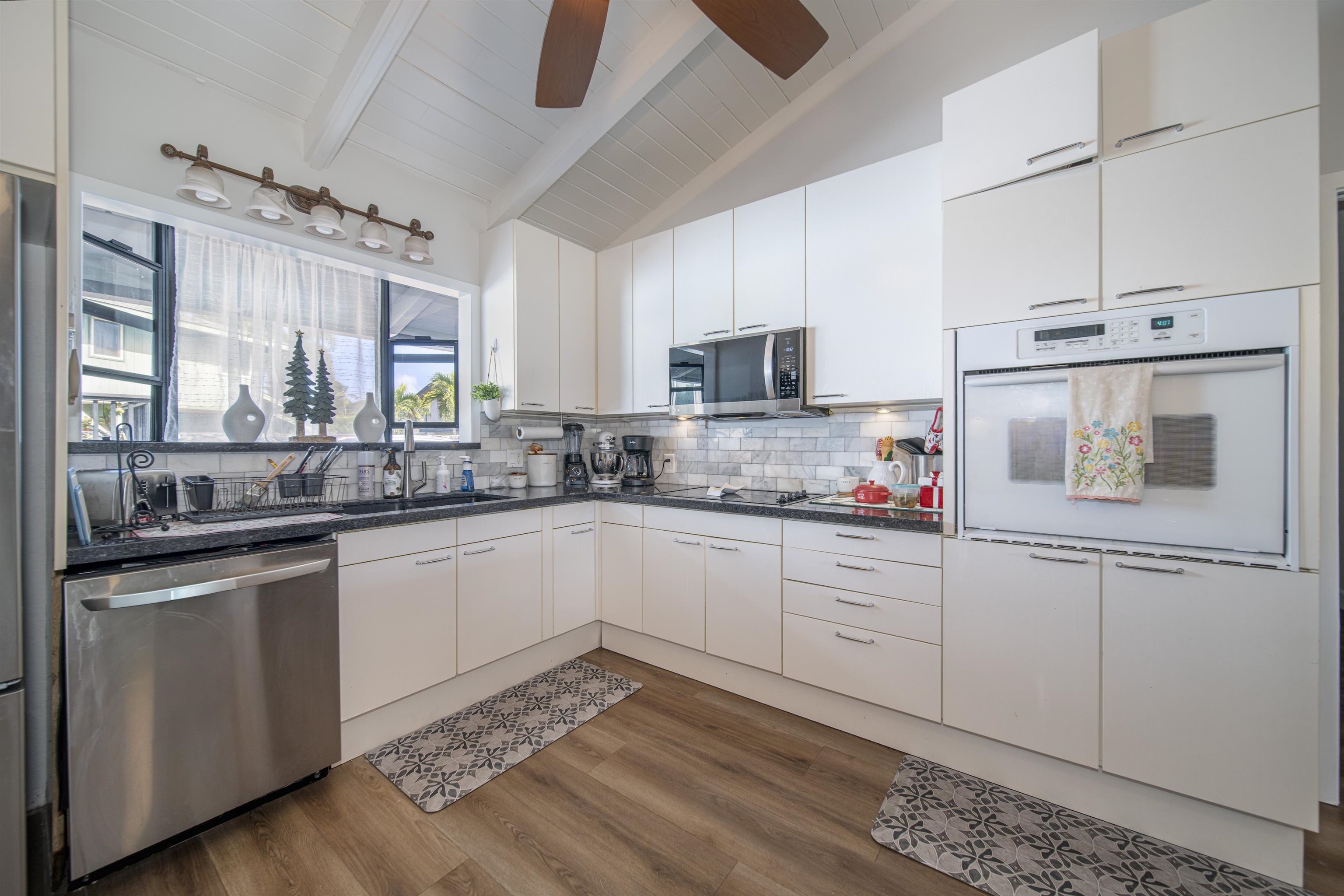 4996 Lower Honoapiilani Road Lahaina, HI 96761 - Photo 22 of 37 a kitchen with a sink cabinets and window