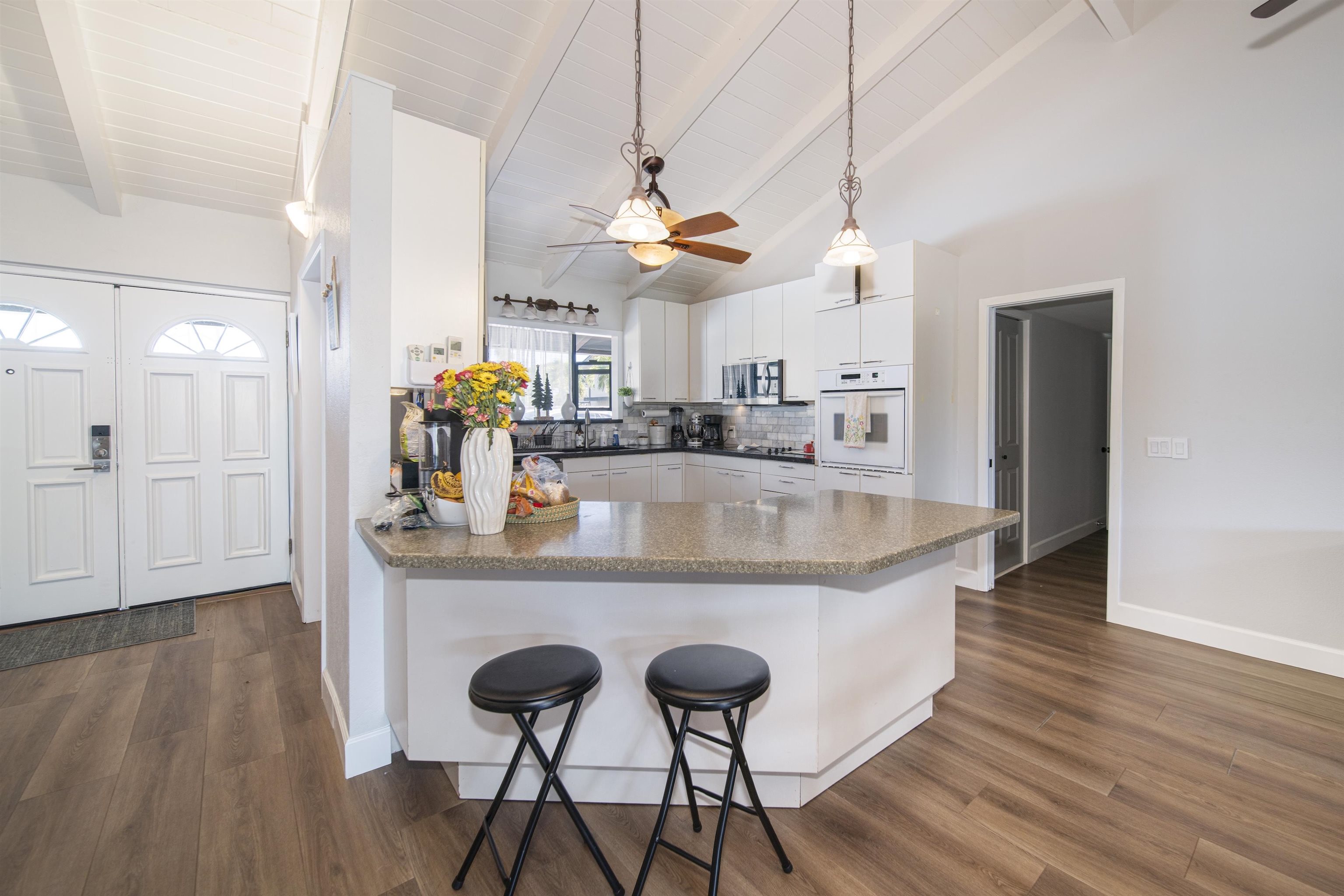 4996 Lower Honoapiilani Road Lahaina, HI 96761 - Photo 23 of 37 a kitchen with stainless steel appliances granite countertop a kitchen island a stove a refrigerator a sink and dishwasher with wooden floor