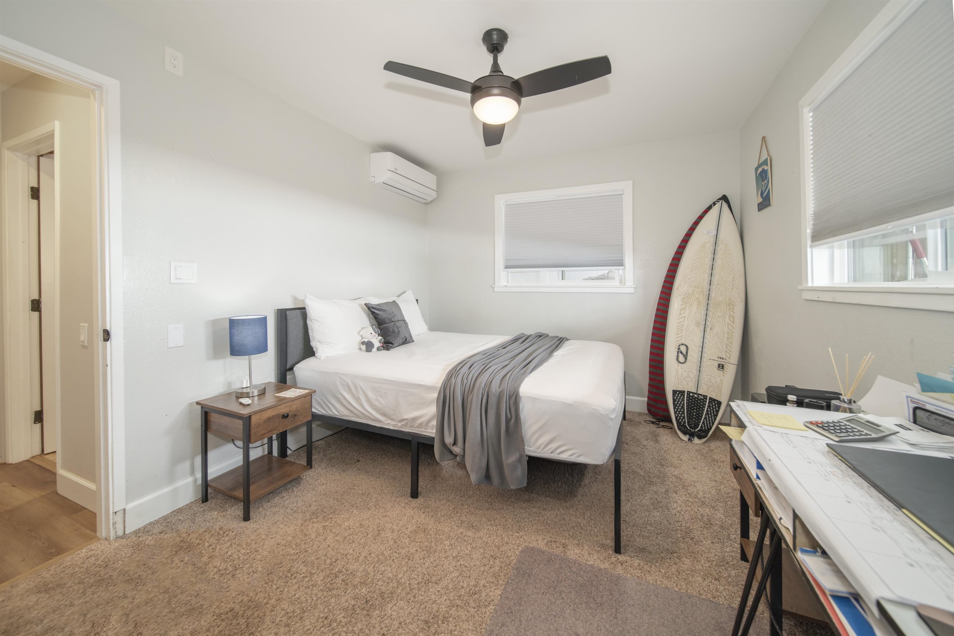 4996 Lower Honoapiilani Road Lahaina, HI 96761 - Photo 28 of 37 a bedroom with a bed a desk and a chandelier