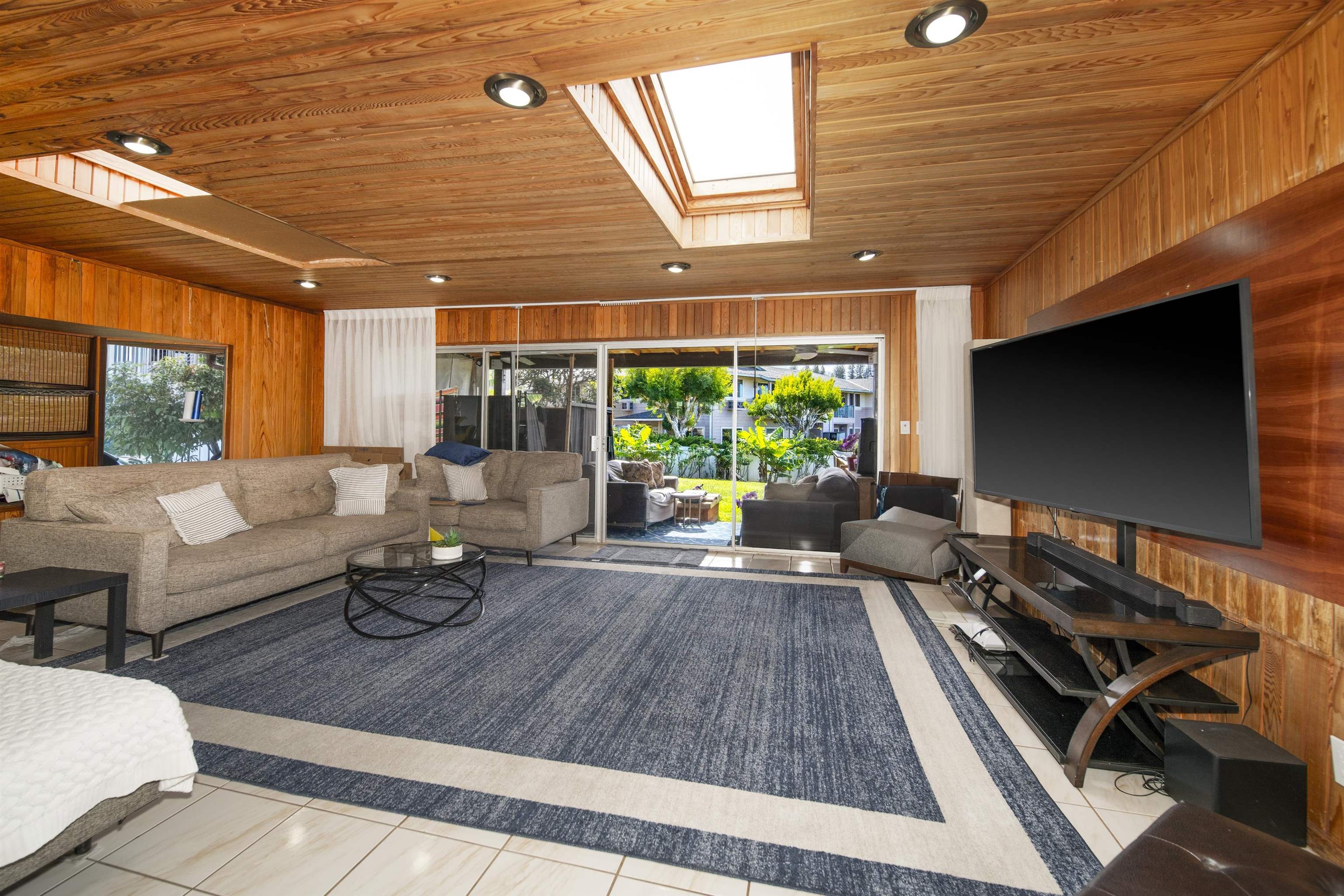 4996 Lower Honoapiilani Road Lahaina, HI 96761 - Photo 6 of 37 a living room with furniture flat screen tv and a large window