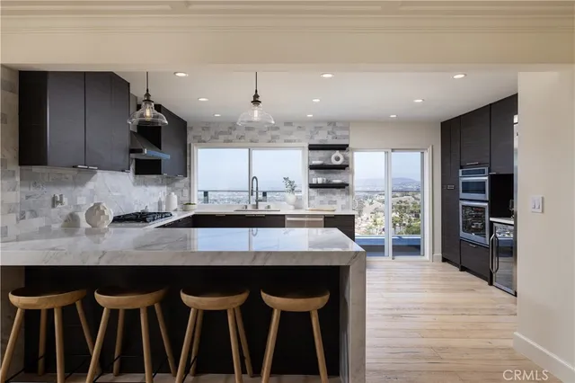 a kitchen with kitchen island granite countertop a sink and a stove top oven