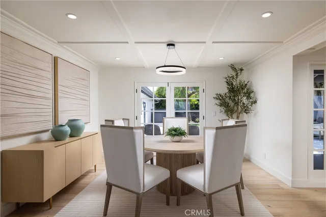 a dining room with furniture a chandelier and wooden floor