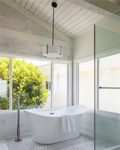 a white bath tub sitting in a bathroom next to a window