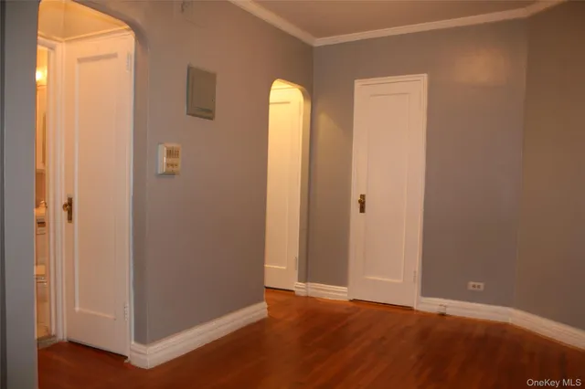 an empty room with wooden floor and window