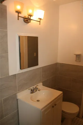 a bathroom with a sink a toilet and mirror