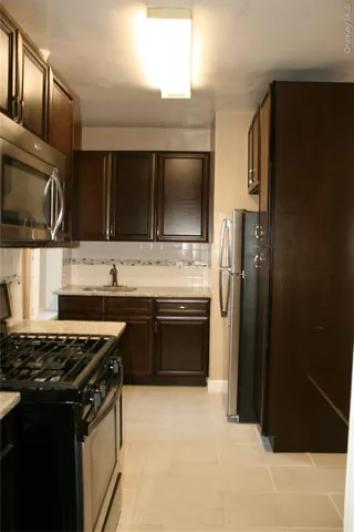 a kitchen with stainless steel appliances a sink stove and refrigerator