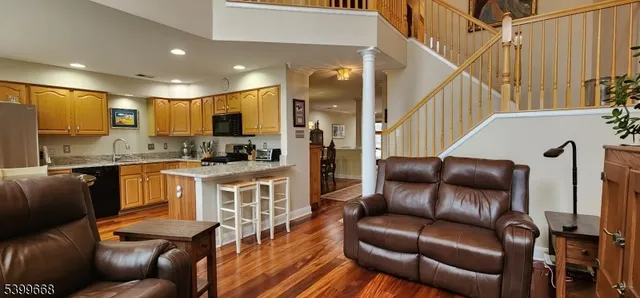 a living room with stainless steel appliances furniture and a kitchen view