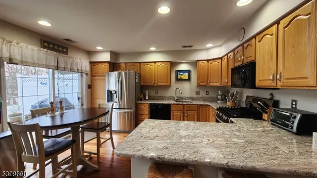 a living room with stainless steel appliances furniture and a kitchen view