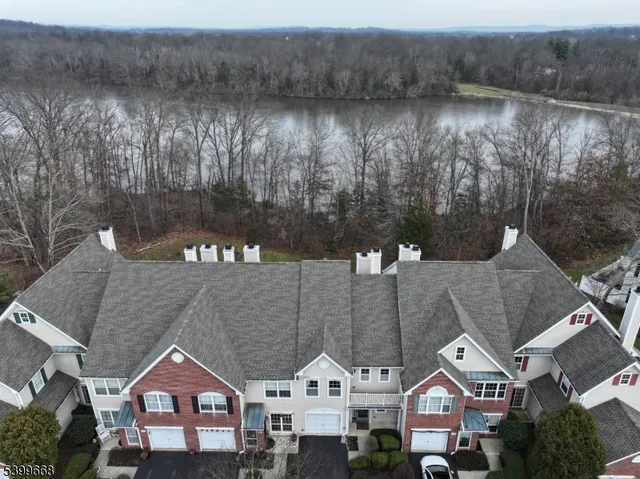 a front view of a house with a yard and lake view