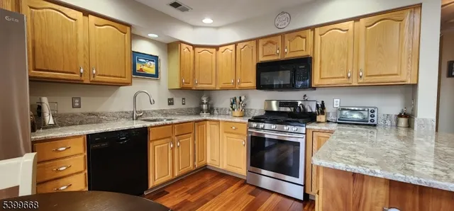 a kitchen with stainless steel appliances granite countertop a stove sink microwave and cabinets