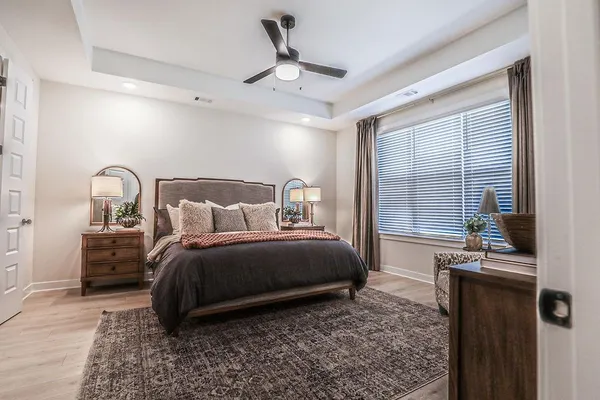 a bedroom with a bed wooden floor and window