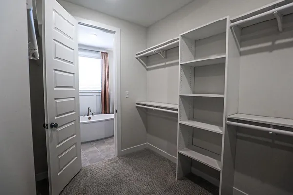 a view of an empty room with cabinet and a window