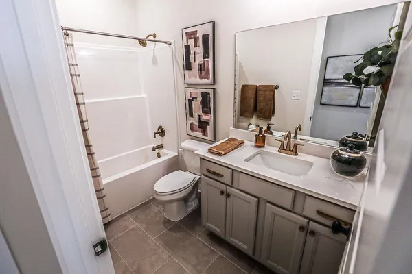 a bathroom with a sink a toilet a mirror and shower