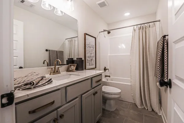 a bathroom with a granite countertop sink a toilet and shower