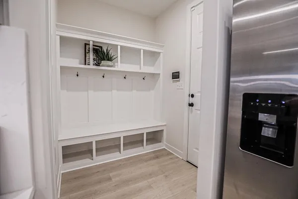 a view of an empty room with wooden floor and closet