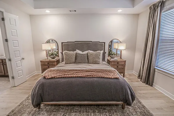 a bedroom with a bed and wooden floor