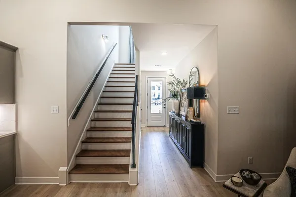 a view of a hallway with wooden floor and stairs