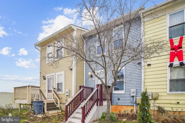 a front view of a house with large trees