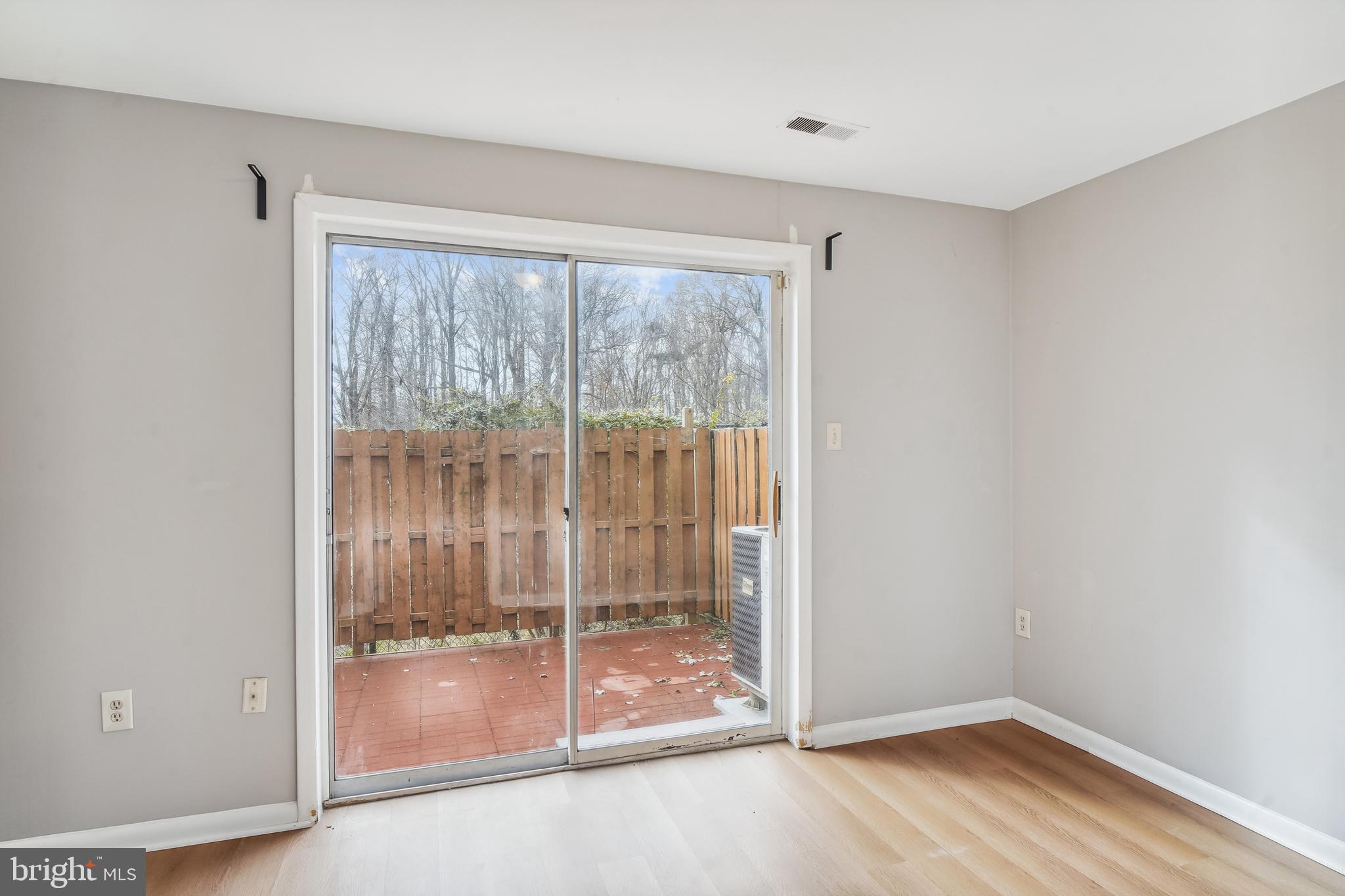 13725 Avonshire Drive Silver Spring, MD 20904 - Photo 16 of 26 a view of an empty room with wooden floor and door