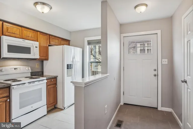 a kitchen with a stove top oven and refrigerator