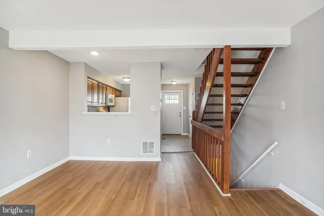 a view of a hallway with wooden floor and stairs
