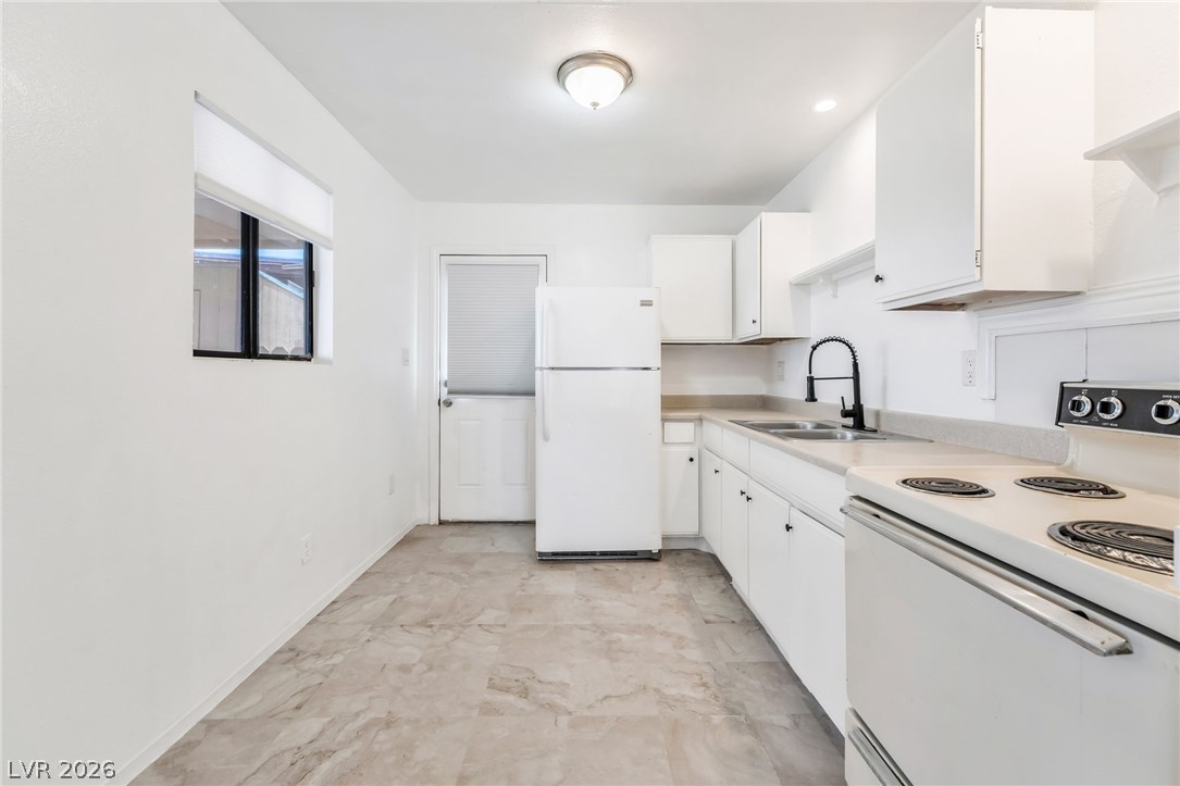 242 Nebraska Avenue Henderson, NV 89015 - Photo 39 of 46 Kitchen with white appliances, white cabinetry, and light countertops