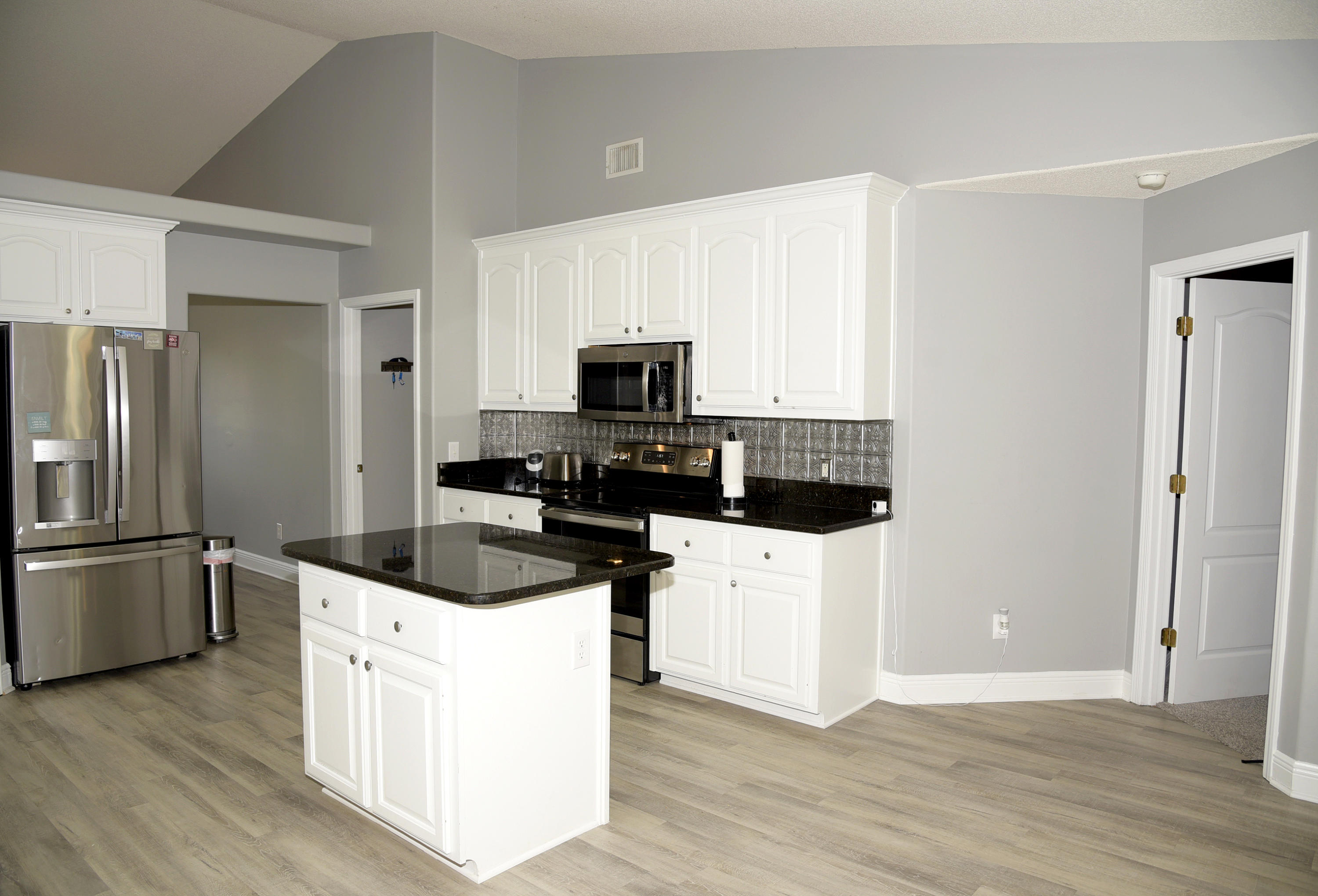 658 Territory Lane Crestview, FL 32536 - Photo 14 of 40 a kitchen with stainless steel appliances a refrigerator a stove a microwave and wooden floor