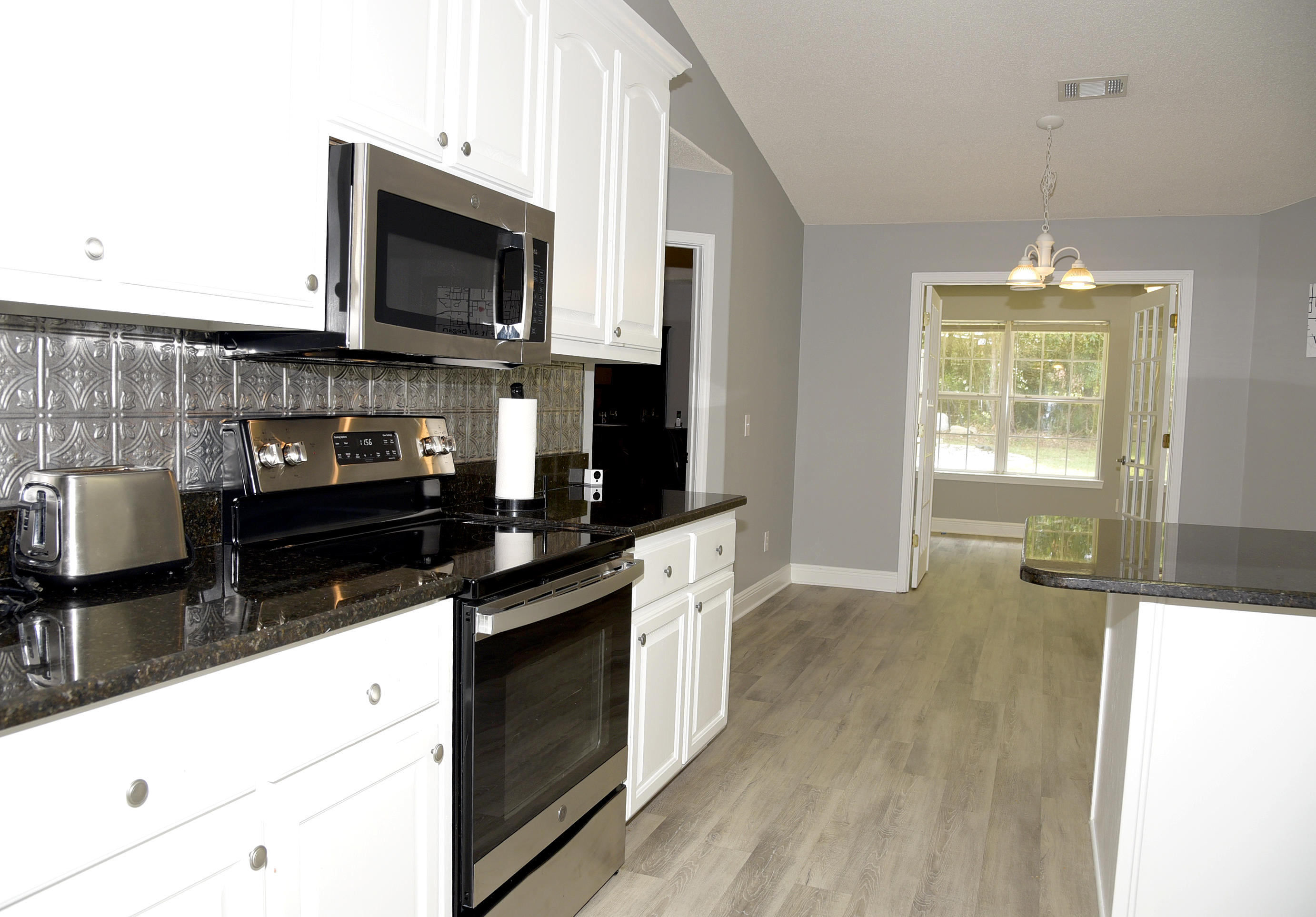 658 Territory Lane Crestview, FL 32536 - Photo 18 of 40 a kitchen with granite countertop a stove and a microwave