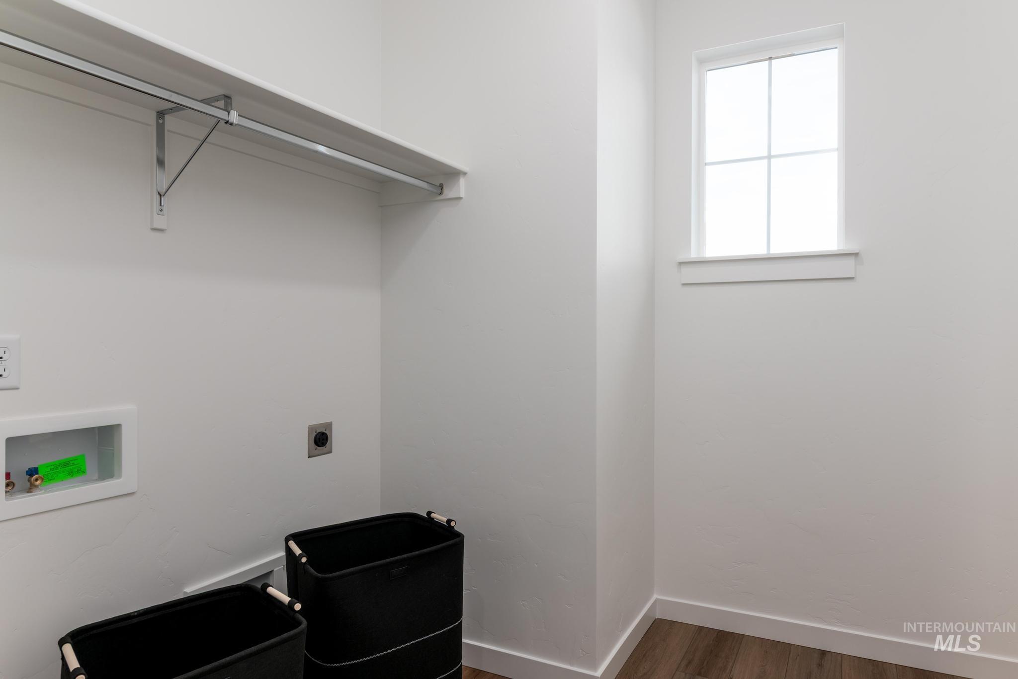 14817 Wing Spread Drive Caldwell, ID 83607 - Photo 10 of 19 Laundry area with wood-finish flooring, white walls, and a window for natural light
