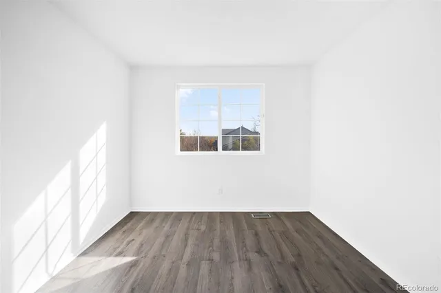 a view of a small space with wooden floor and a window