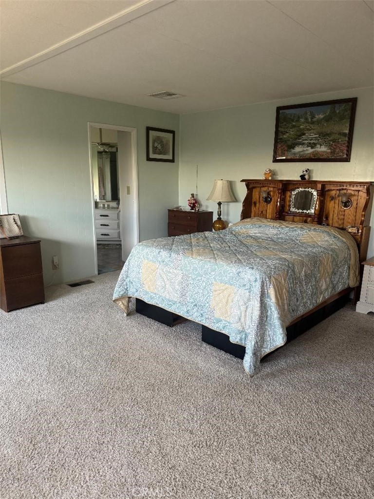 41004 Cheyenne Trail Cherry Valley, CA 92223 - Photo 6 of 10 a spacious bedroom with a bed and a desk