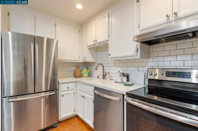 a kitchen with stainless steel appliances a refrigerator sink and cabinets